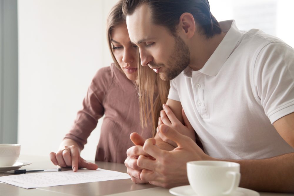 A male and female couple sitting in front of a laptop sorting out their life insurance policy