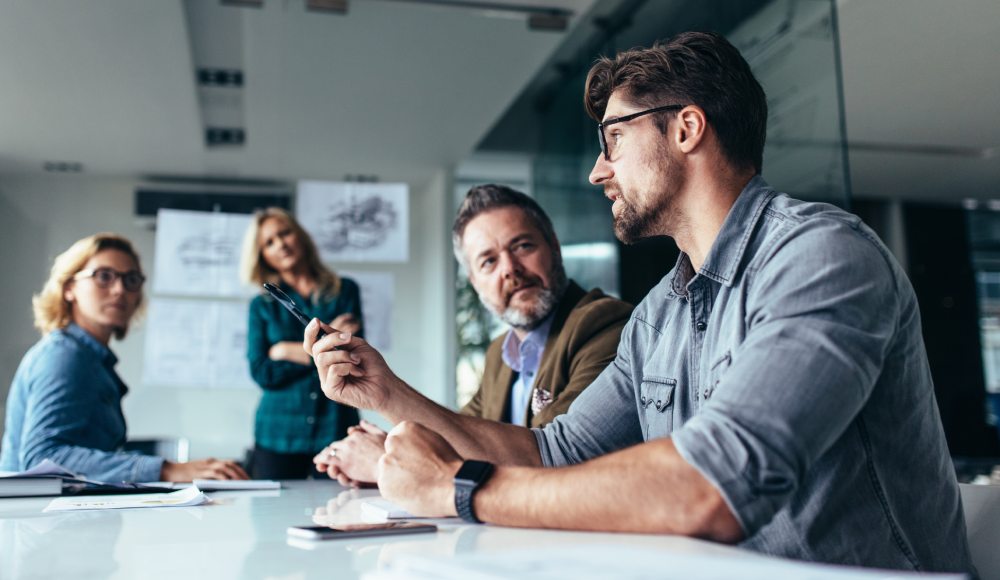 Four people at a meeting discussing key person revenue protection for their business